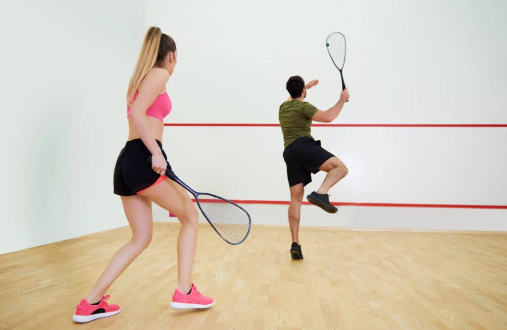 athletic couple playing squash together