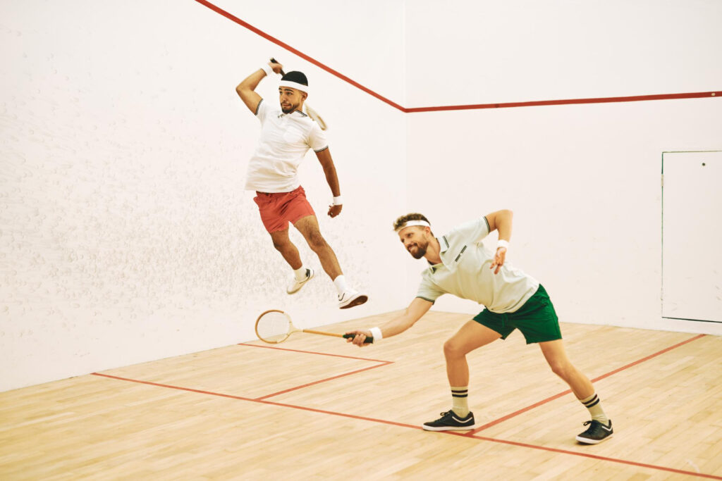 pro squash players jumping for ball